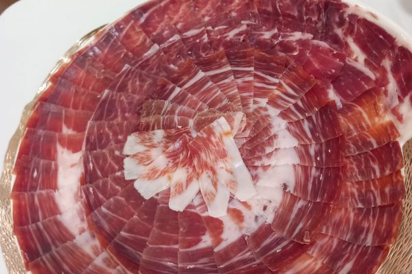 Plato de jamón ibérico de alta calidad, cortado profesionalmente en Málaga, ideal para eventos y degustaciones. Descubre el auténtico sabor del Jamón Ibérico.