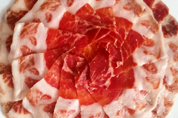 Plato de jamón ibérico de alta calidad, cortado profesionalmente en Málaga, ideal para eventos y degustaciones. Descubre el auténtico sabor del Jamón Ibérico.