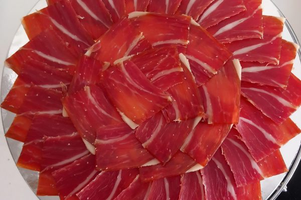 Plato de jamón ibérico de alta calidad, cortado profesionalmente en Málaga, ideal para eventos y degustaciones. Descubre el auténtico sabor del Jamón Ibérico.