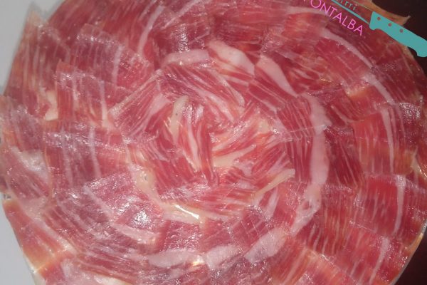 Plato de jamón ibérico de alta calidad, cortado profesionalmente en Málaga, ideal para eventos y degustaciones. Descubre el auténtico sabor del Jamón Ibérico.