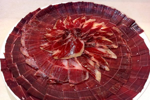 Plato de jamón ibérico de alta calidad, cortado profesionalmente en Málaga, ideal para eventos y degustaciones. Descubre el auténtico sabor del Jamón Ibérico.