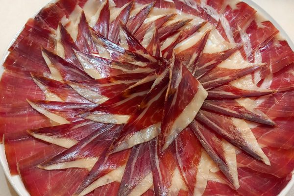 Plato de jamón ibérico de alta calidad, cortado profesionalmente en Málaga, ideal para eventos y degustaciones. Descubre el auténtico sabor del Jamón Ibérico.