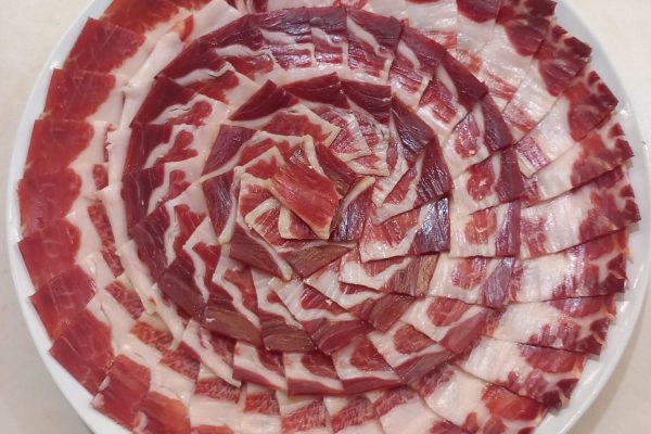 Plato de jamón ibérico de alta calidad, cortado profesionalmente en Málaga, ideal para eventos y degustaciones. Descubre el auténtico sabor del Jamón Ibérico.