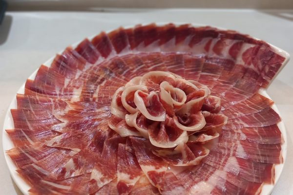Plato de jamón ibérico de alta calidad, cortado profesionalmente en Málaga, ideal para eventos y degustaciones. Descubre el auténtico sabor del Jamón Ibérico.