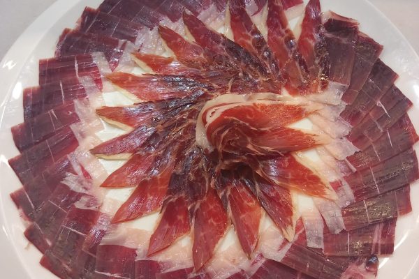 Plato de jamón ibérico de alta calidad, cortado profesionalmente en Málaga, ideal para eventos y degustaciones. Descubre el auténtico sabor del Jamón Ibérico.