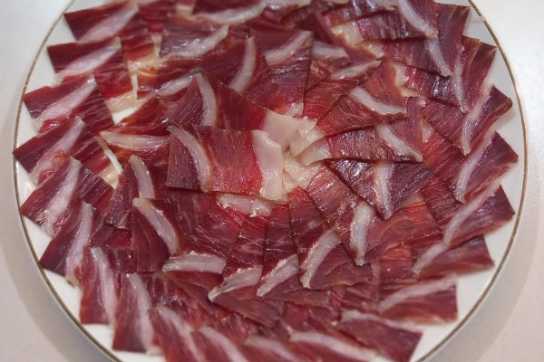 Plato de jamón ibérico de alta calidad, cortado profesionalmente en Málaga, ideal para eventos y degustaciones. Descubre el auténtico sabor del Jamón Ibérico.